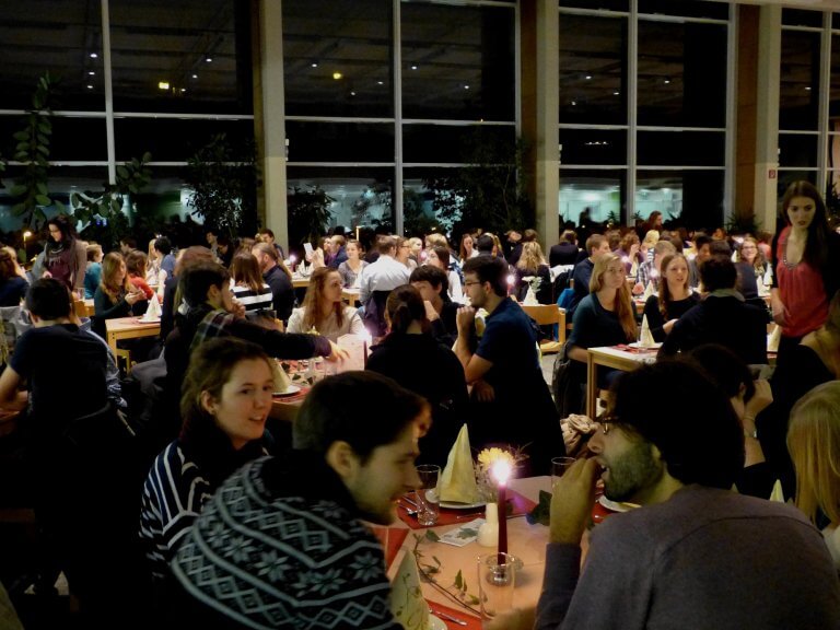 Willkommensdinner Studis Studierende sitzen im Speisesaal, der mit kerzenschein beleuchtet ist